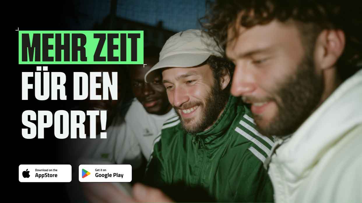 Drei Personen in Freizeitkleidung, eine trägt eine grüne Jacke mit Kapuze, eine andere ein weißes Shirt mit grünem Logo, sie schauen auf ein Smartphone.