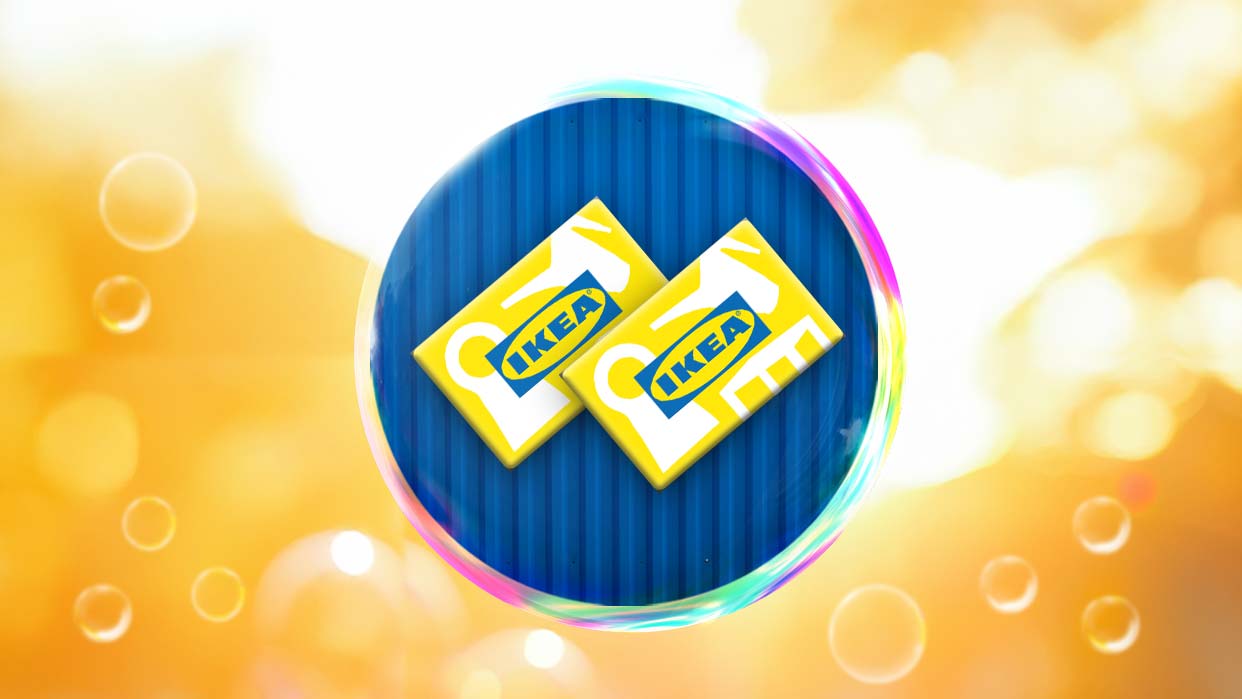 Zwei gelbe Ikea-Gutscheine mit blauem Logo vor blauem Hintergrund, umgeben von einem bunten Seifenblase und orangefarbenen Lichtpunkten.
