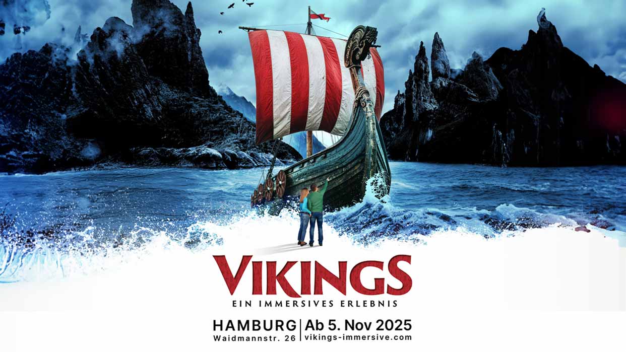 Ein Wikingerschiff mit rotem und weißen Segel fährt durch stürmisches Wasser. Im Hintergrund sind dunkle Berge und ein klarer Himmel zu sehen. Text: 'VIKINGS EIN IMMERSIVES ERLEBNIS HAMBURG Ab 5. Nov 2025 Waidmannstr. 26 vikings-immersive.com'.