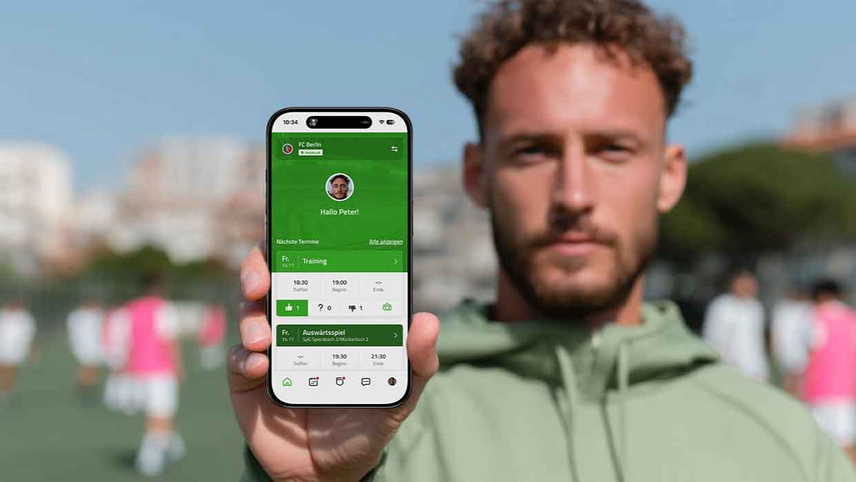 Personen in Freizeitkleidung, eine trägt eine grüne Jacke mit Kapuze, und hält ein Handy mit einer geöffneten App hoch.