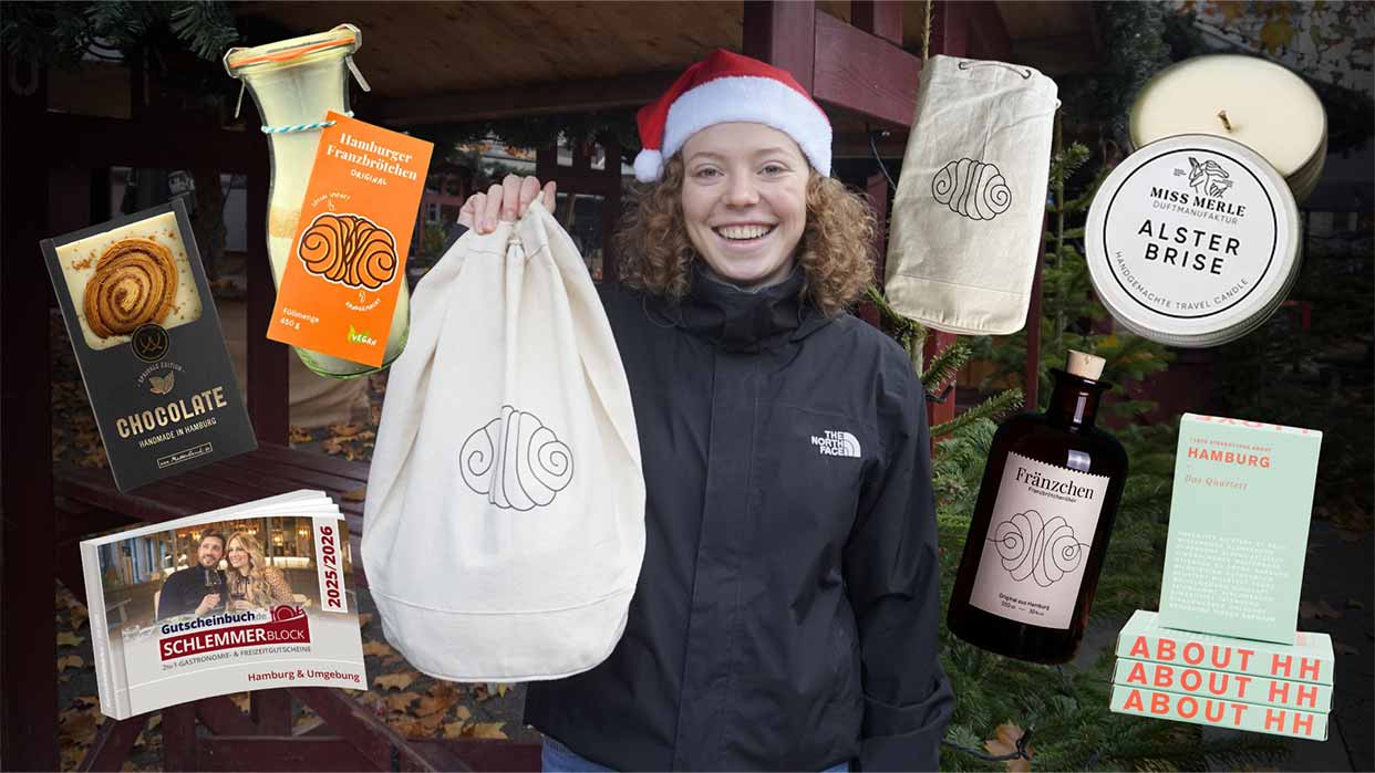 Person mit rotem Weihnachtsmütze und schwarzer Jacke hält einen weißen Beutel mit einem stilisierten Franzbrötchen-Logo, umgeben von verschiedenen Produkten mit demselben Logo.