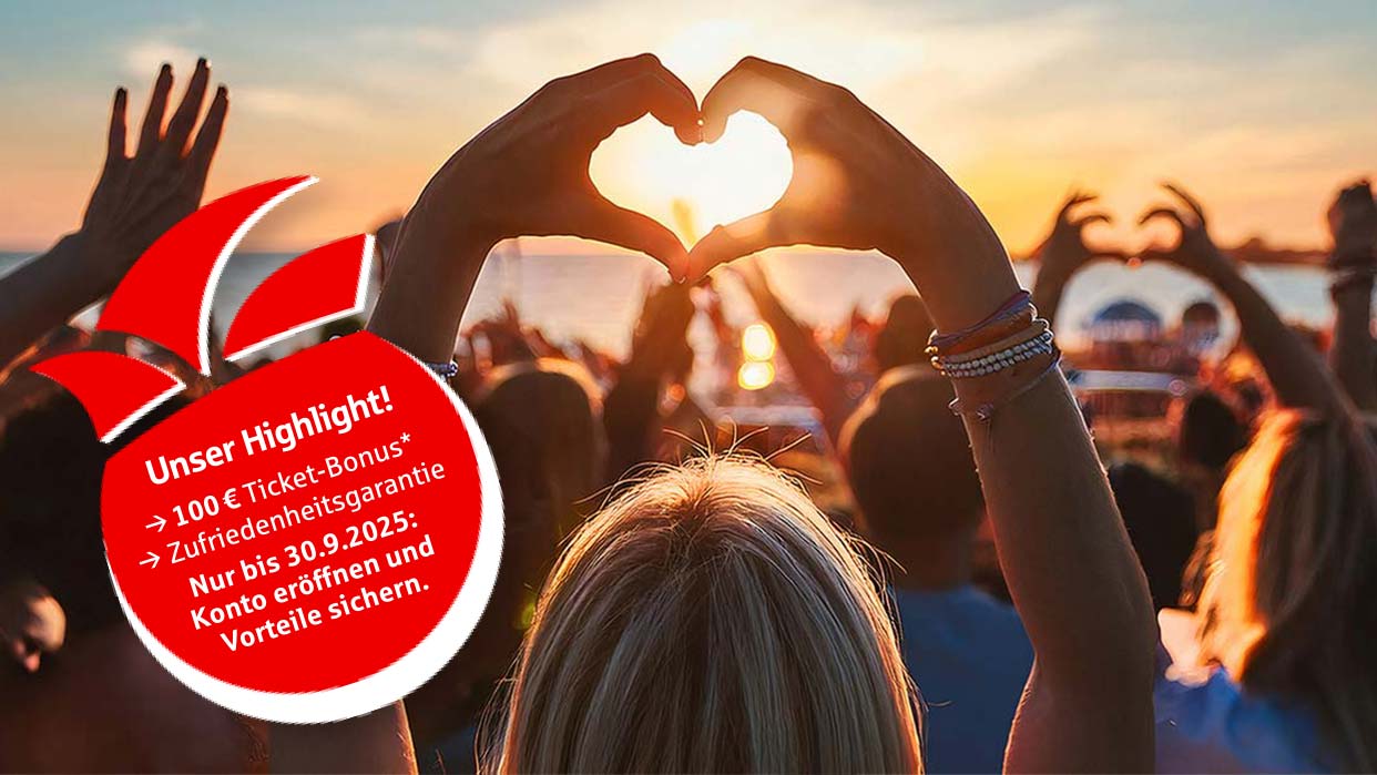 Eine Frau formt mit ihren Händen ein Herz vor Sonnenuntergang am Strand, andere Menschen im Hintergrund