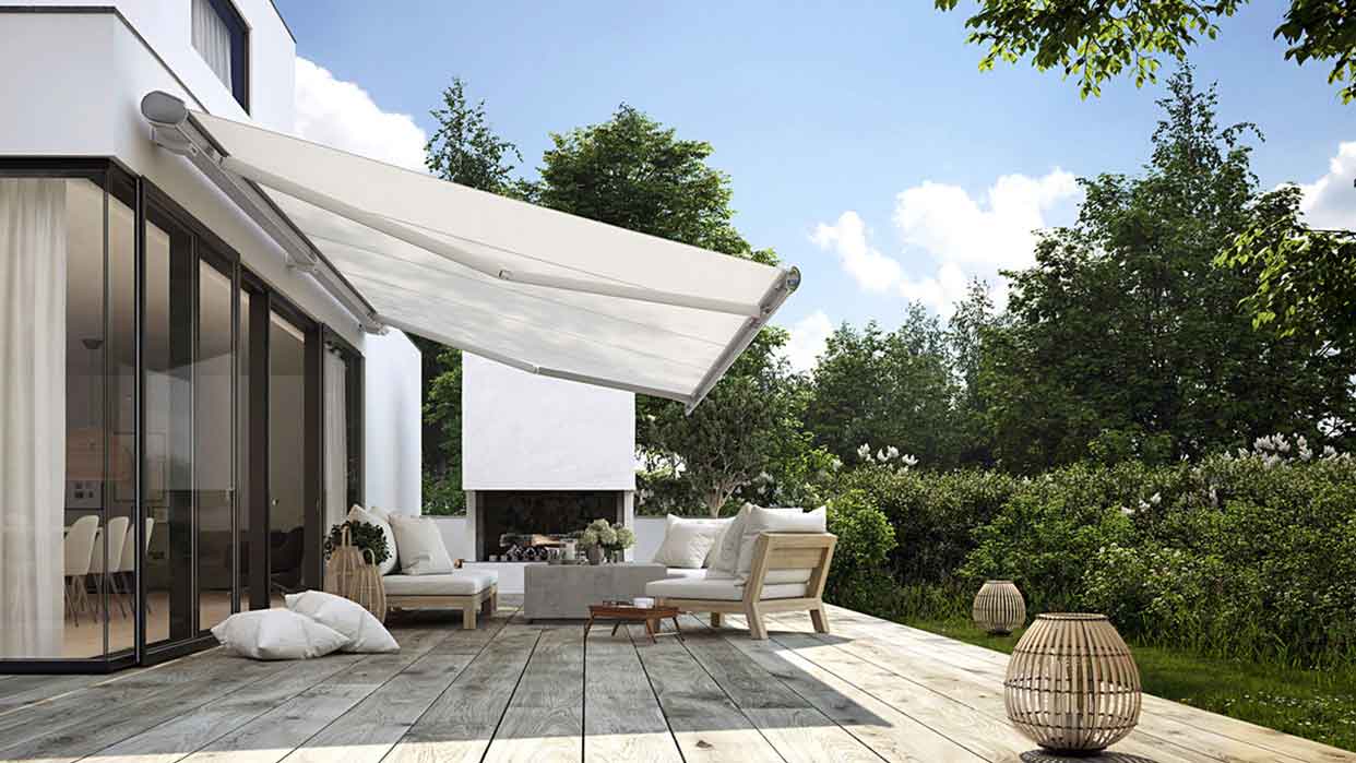 Terrasse mit Holzbelag, moderner Markise, Lounge-Möbeln und Garten mit Büschen und Bäumen.